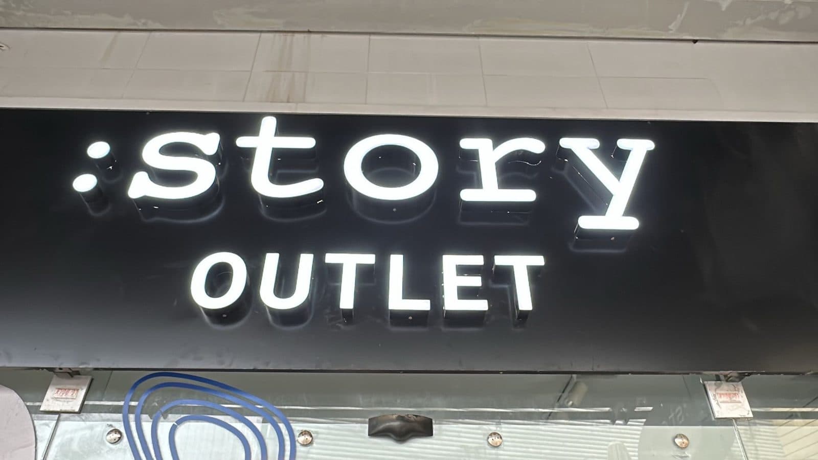 אותיות story OUTLET מוארות לבנות על רקע שחור