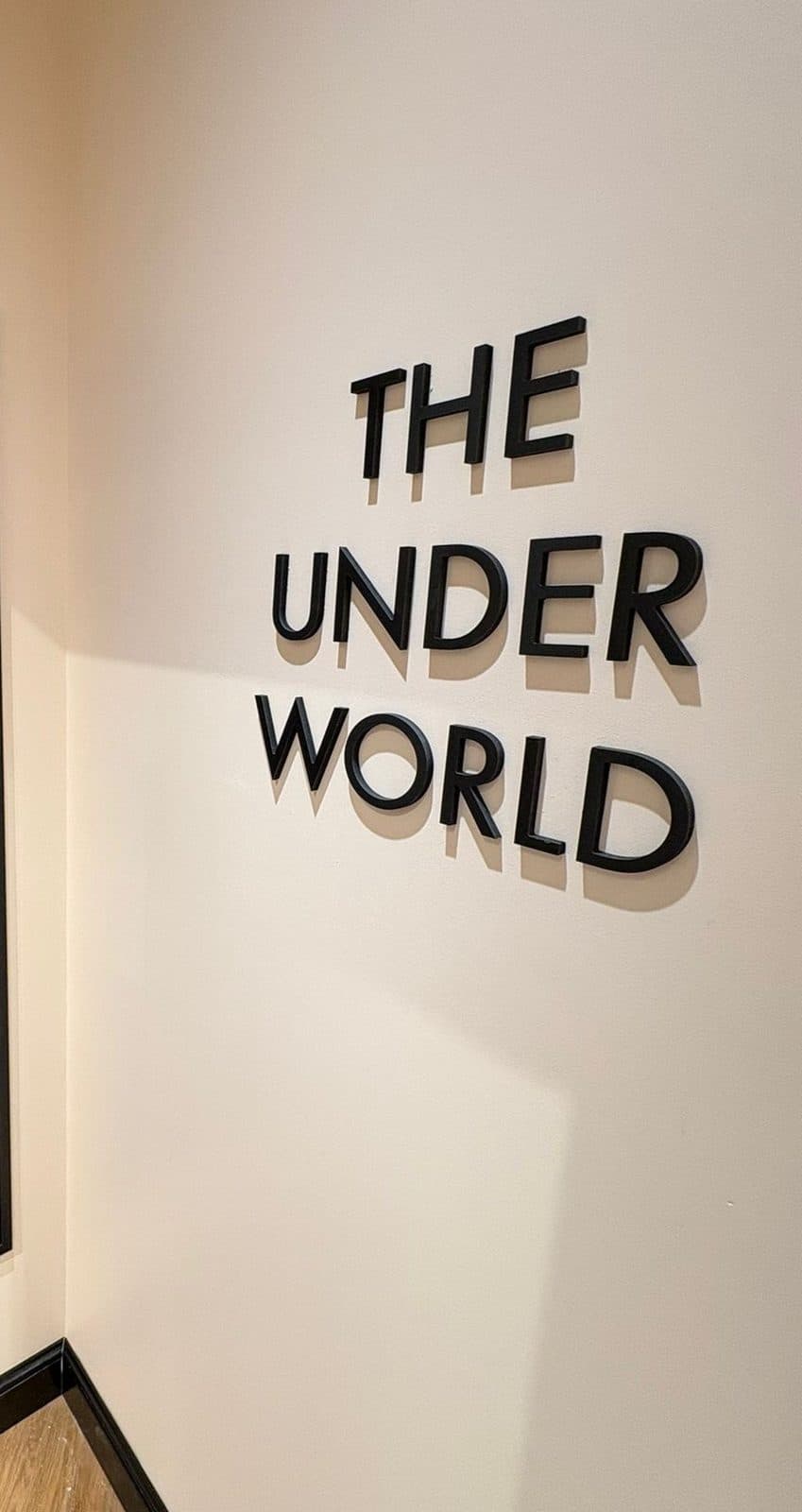 אותיות THE UNDER WORLD שחורות תלת-ממדיות על קיר פנימי