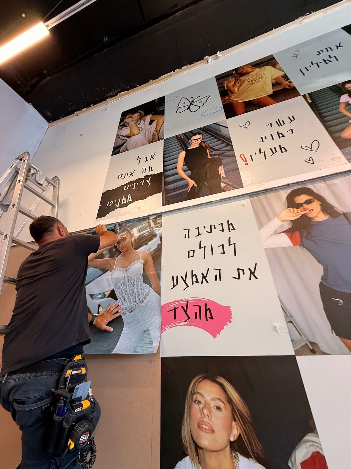 קיר תמונות וכיתובים מודפס בחנות Adika Studio — מתקין בעבודה