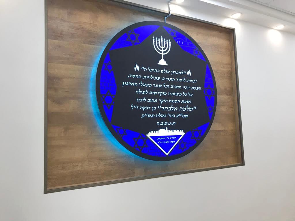 שלט הנצחה מואר בבית הכנסת